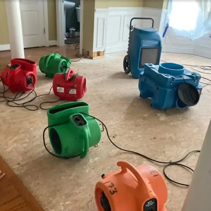 Air movers and a dehumidifier positioned across a wet exposed subfloor